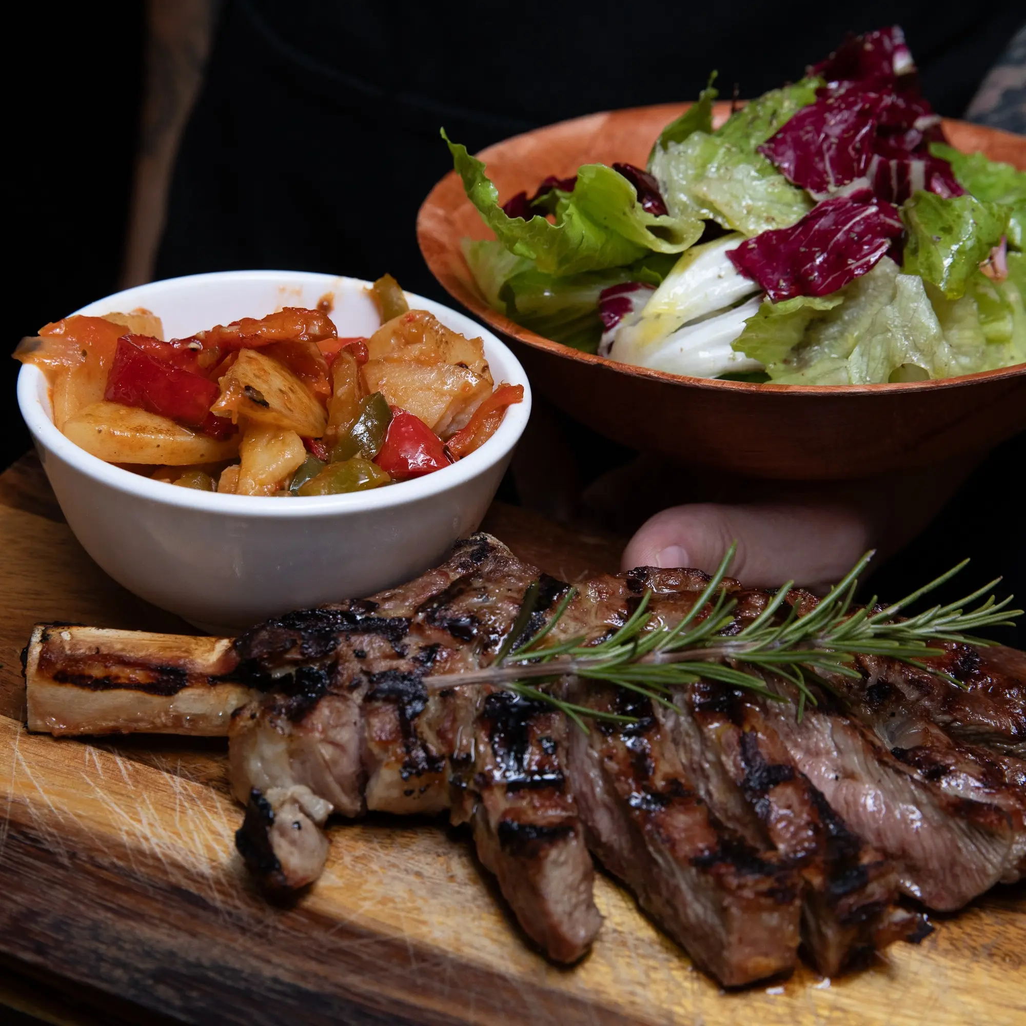 A picture of a piece of steak with a side of salad.