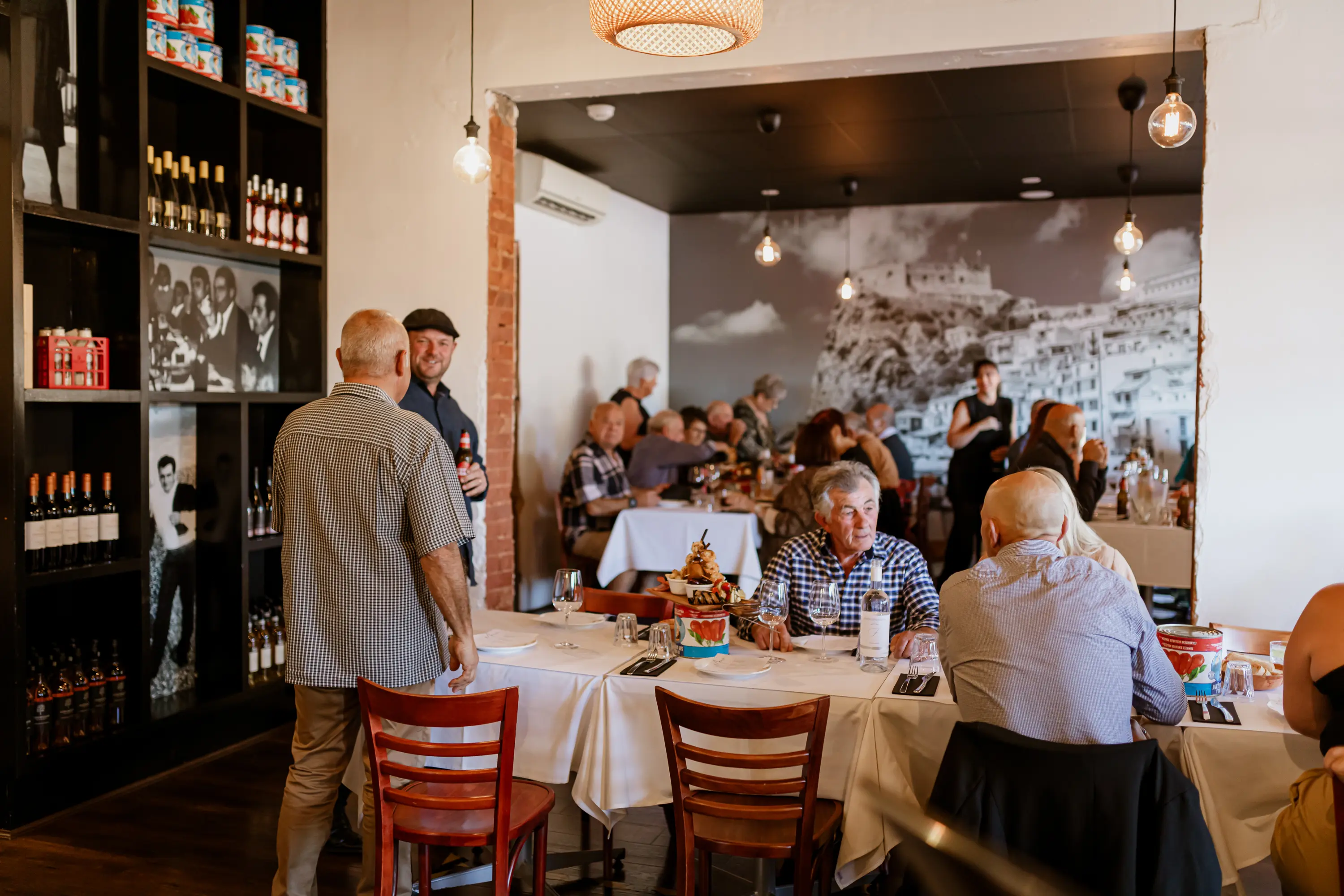 People sitting and talking at a table eating food at Paladino's Cucina.